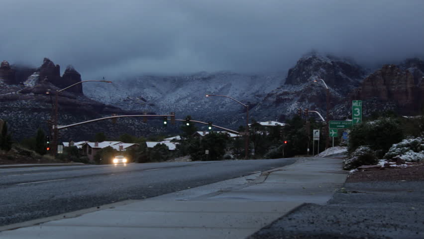 Traffic moves slowly by in the cold, early morning as the thick, heavy clouds lift from the snowy mountains of Sedona, Arizona.