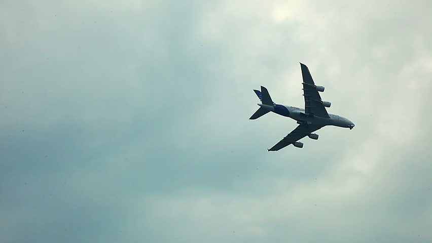 a380 air craft fly over horizon in cloudy sky - air show