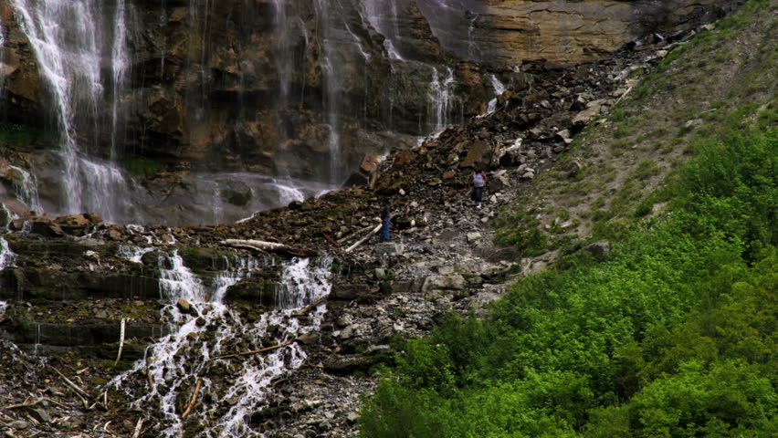People on the rocky hillside at the bottom of Bridal Veil Falls in Provo Canyon, Utah.