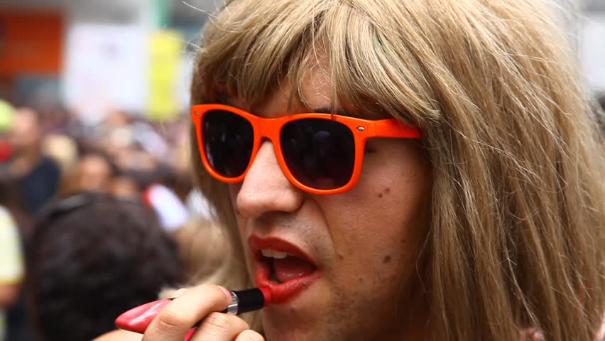 SAN PAULO, BRAZIL - CIRCA JUNE 2011: A man puts on lipstick at the LGBT Gay Pride Parade on Avenida Paulista circa June 2011 in San Paulo.