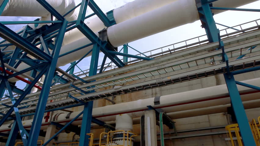 Pan across the blue framing and white water pipes crossing over head from one part of the IDE Ashkelon desalination plant in Israel to another.