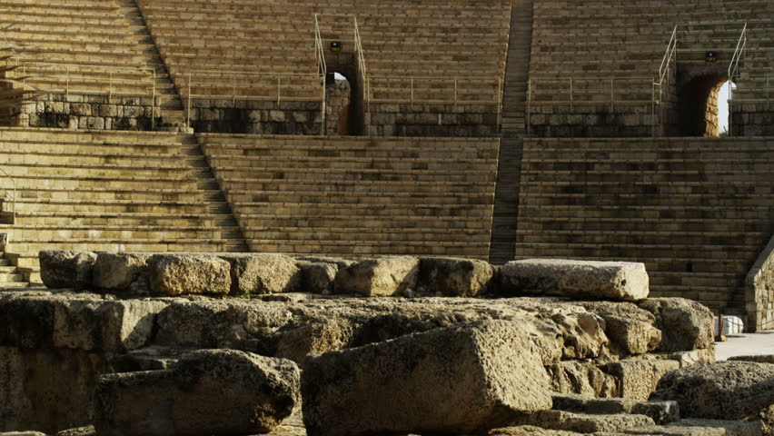 Pan right to left of the Amphitheater at the Caesarean ruins in Israel.  Palm branch in the foreground.  02/28/2011.