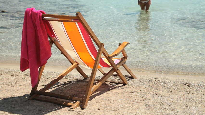 woman coming out of sea sitting  on deckchair