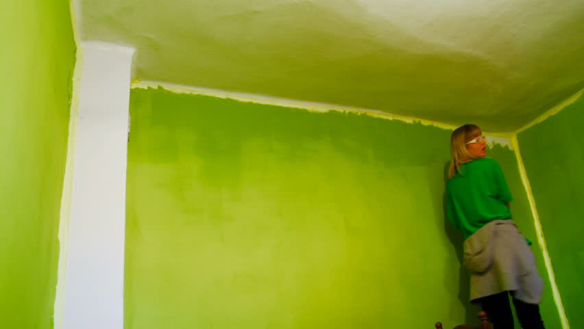 Friends painting a room with green color in new home. Timelapse