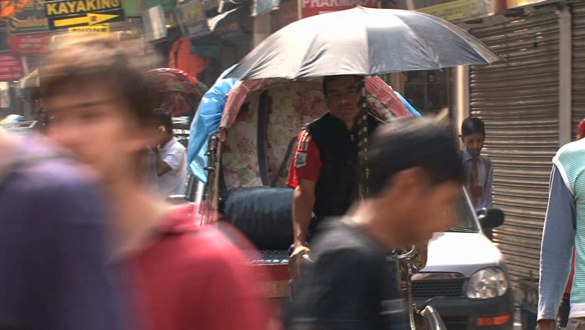 NEPAL - CIRCA MAY, 2011: Busy narrow street packed with cars, tricycle rickshaws and pedestrians.