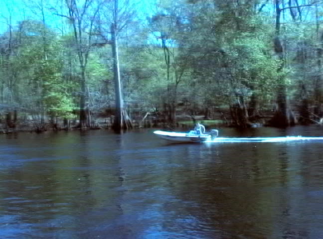A boater motors by on the Santa Fe River in Florida.