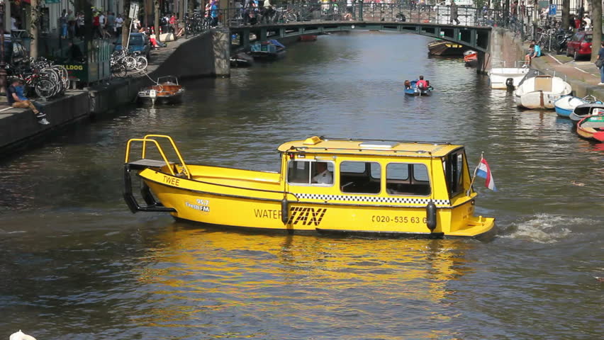 AMSTERDAM, HOLLAND - AUGUST 1: Canal taxi delivers passengers on a historic canal on August 1, 2011. The Amsterdam canals are on the Unesco World Heritage list.