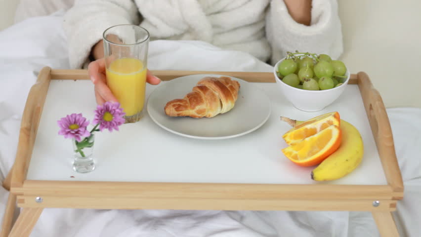 Woman eating breakfast in bed