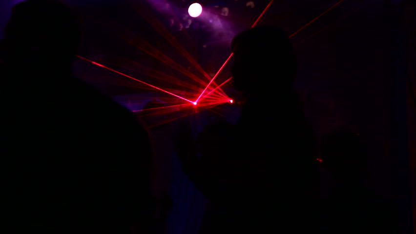 Dancing at the disco. People dancing at a disco where there is a beautiful laser show.