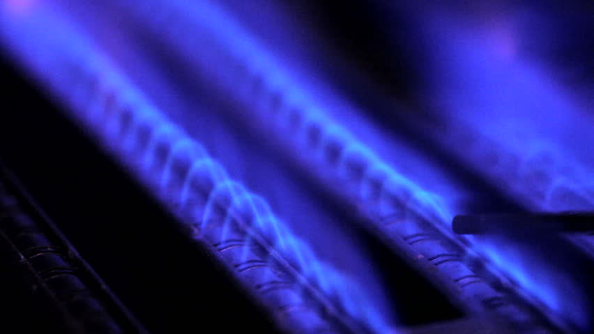 Blue flames of a gas burner inside of a boiler