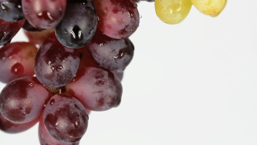 Delicious, juicy red and green grapes rotate downward, white background, close-up. 1080p