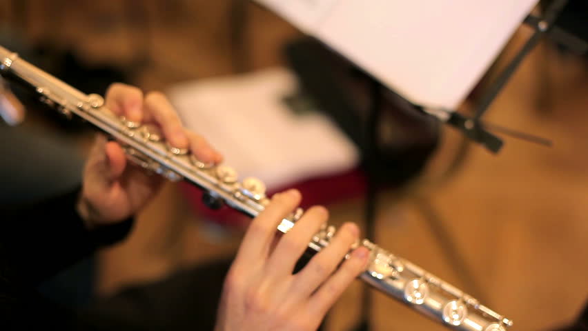 Musician plays the flute. Flutist professionally playing the flute in the orchestra.