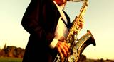 man plays jazz on golden saxophone in nature instrumental