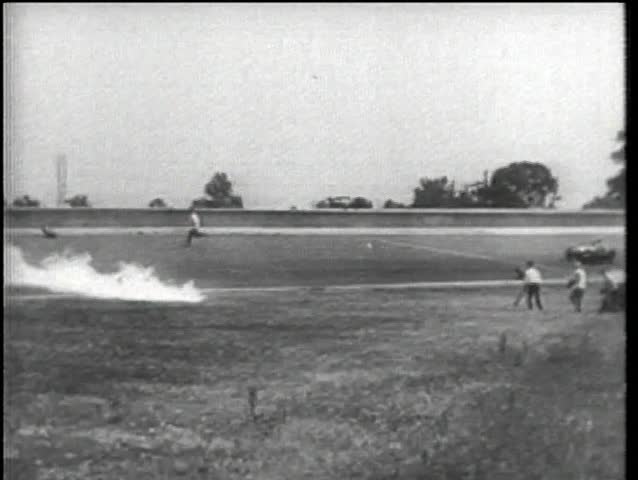 Race car driving through wall of fire to finish line, Indy 500