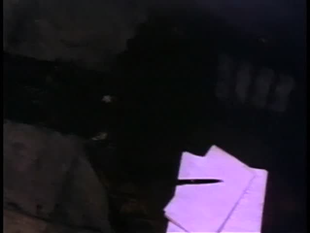 Close-up of gloved hand crumpling letter