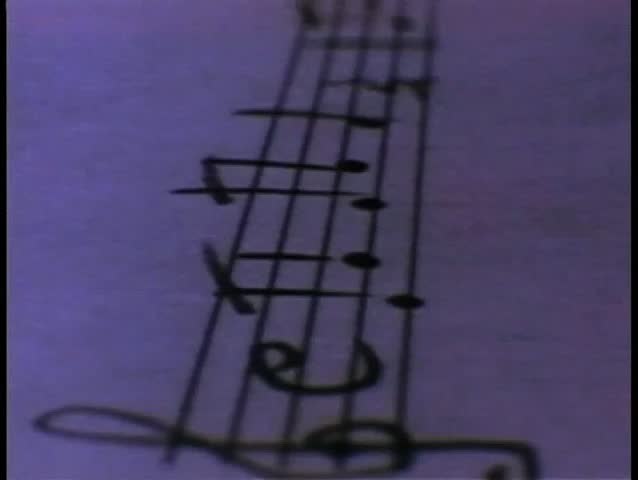 Close-up tracking shot over sheet music to piano keys