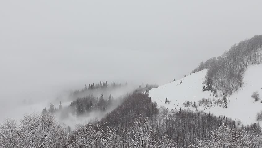 Falling snow in the mountains above the clouds