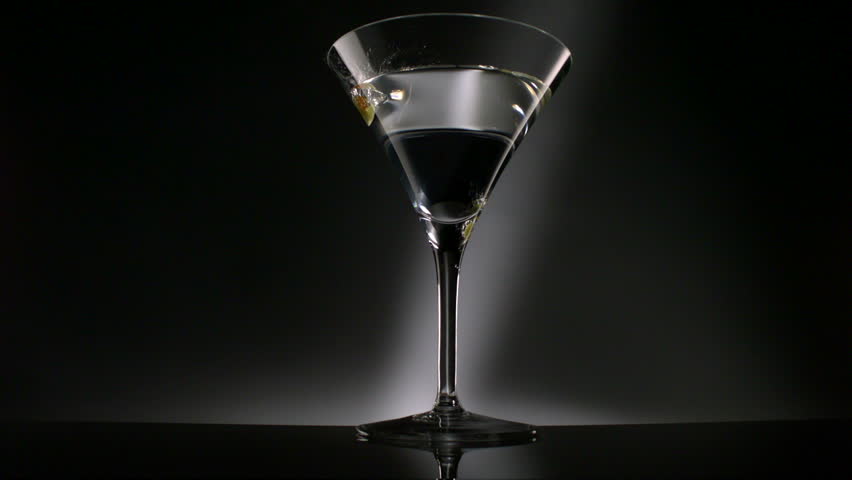 Olive dropped into martini glass