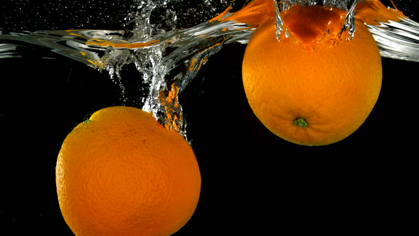 Slo-motion whole orange falling into water