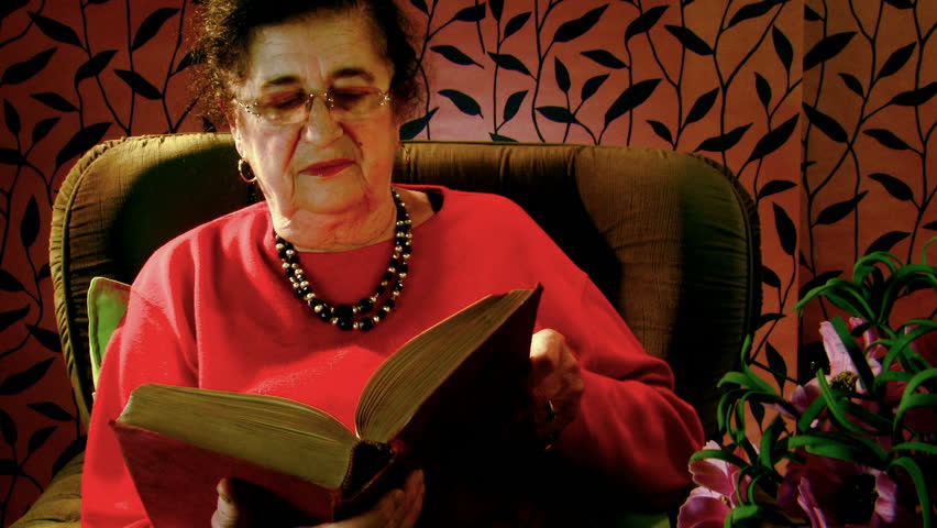 Elderly woman reads the book