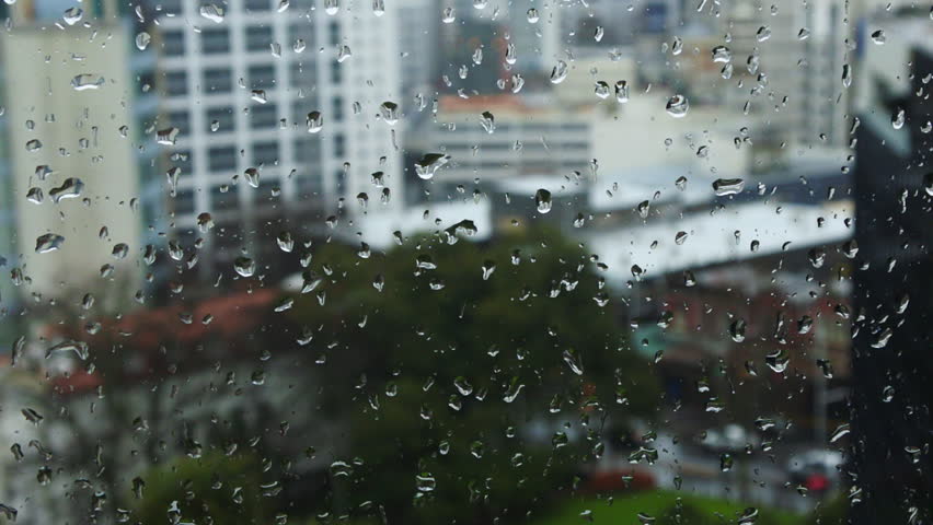 Rain Drops Running Down A Window,with The Blur City Building Landscape