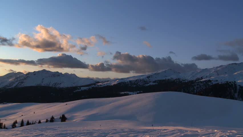 Snow covered mountain valley at sunset