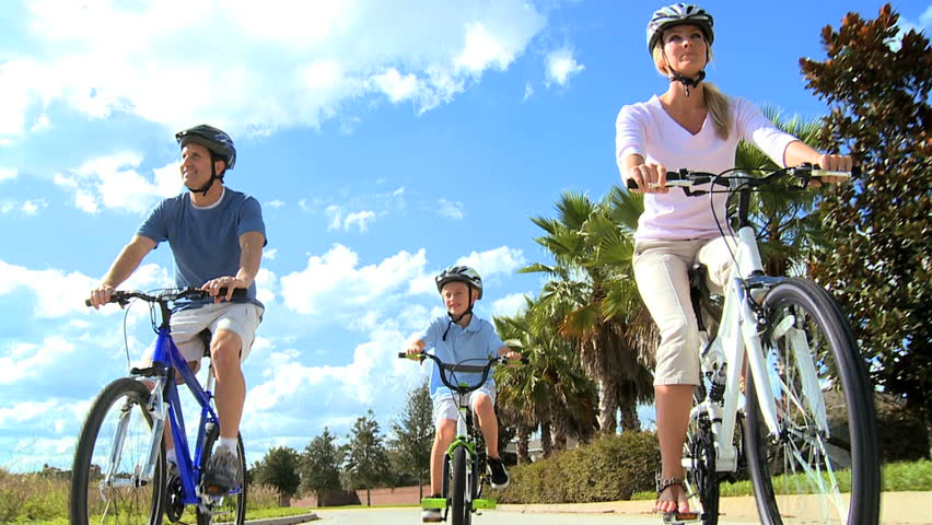 Happy caucasian family cycling in the sunshine