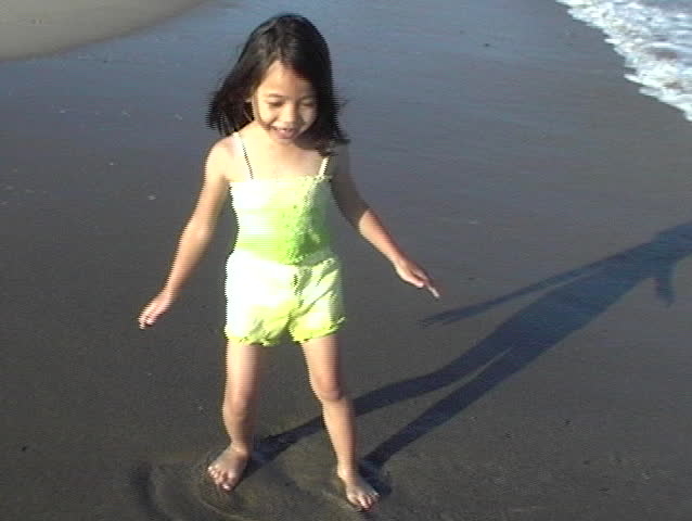 little asian girl chasing waves