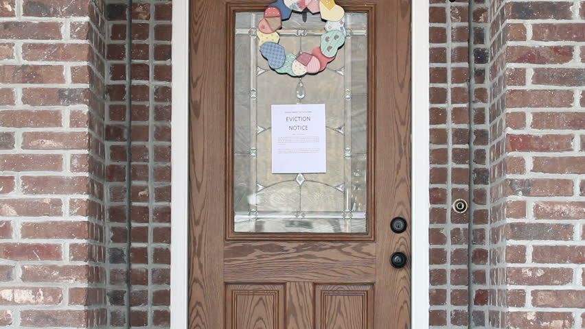 Eviction notice on front door of house as home owner returns.