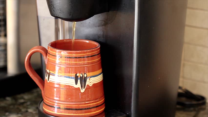 A Modern Coffee Maker Brews into a Single Cup (coffee seen streaming into mug)