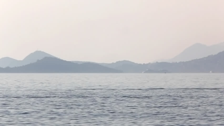 Adriatic sunset scene with a view to the Dubrovnik in the distance. Jet ski watercraft. Location small town Cavtat near Dubrovnik, Croatia.