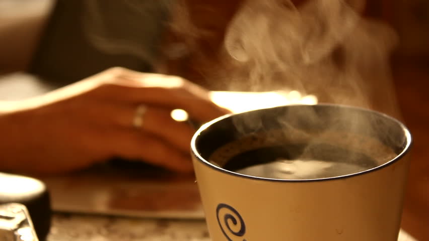 steaming cup of freshly brewed aromatic coffee in the morning on the kitchen table