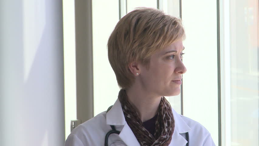 Female doctor is looking at the camera and smiles