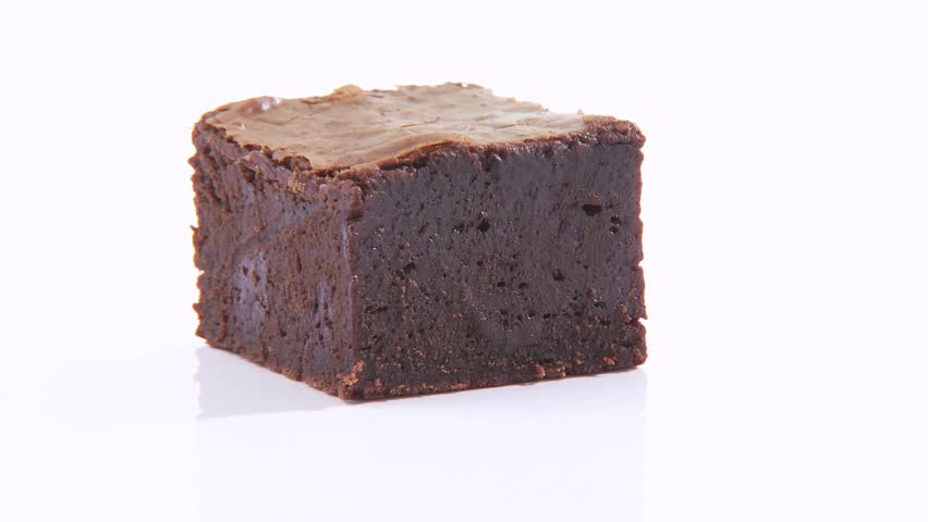 Pouring chocolate sauce around a brownie