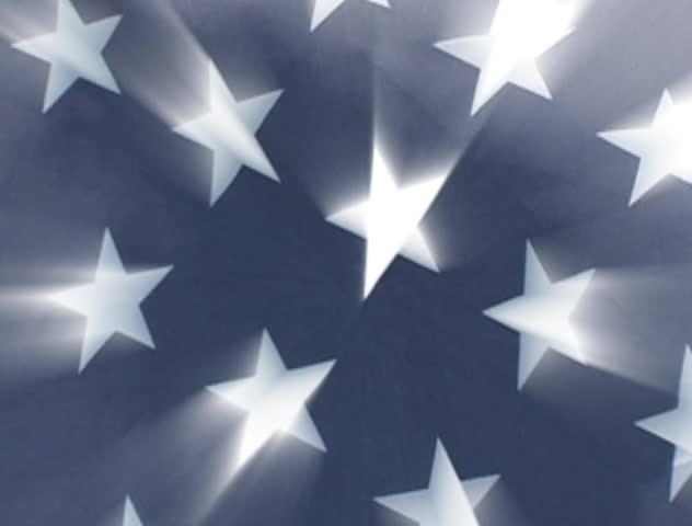 A tight shot of the stars on an American flag with the white stars shining through.
