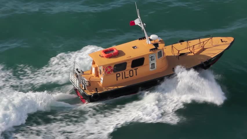 Birds eye view of a yellow pilot boat steaming through the turquoise Caribbean waters.