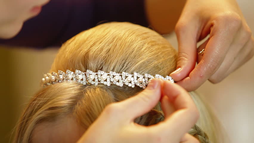 Hairdresser pinning up bride's tiara before the wedding