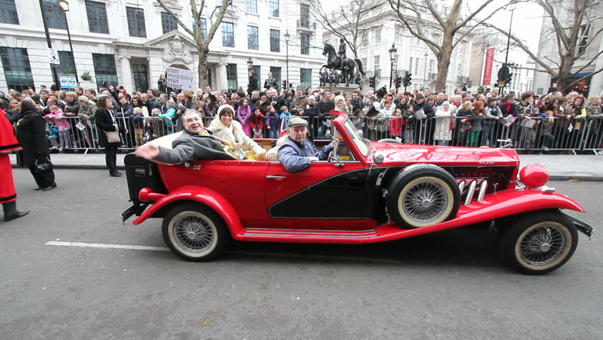 LONDON, UK - JANUARY 11: Russell Grant and Flavia Cacace of the Strictly Come Dancing show in a vintage car and talking to the public in the London New Years Day Parade in London on january 1, 2012.