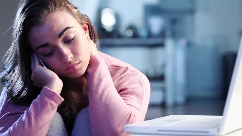 Depressed teenager using mobile phone to hear bad news