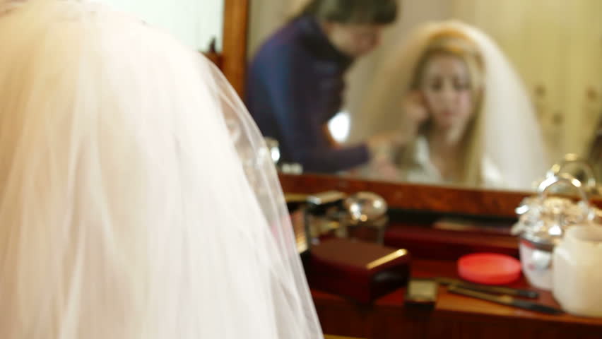 Bridal hairdresser making hairstyle in front of a mirror. 