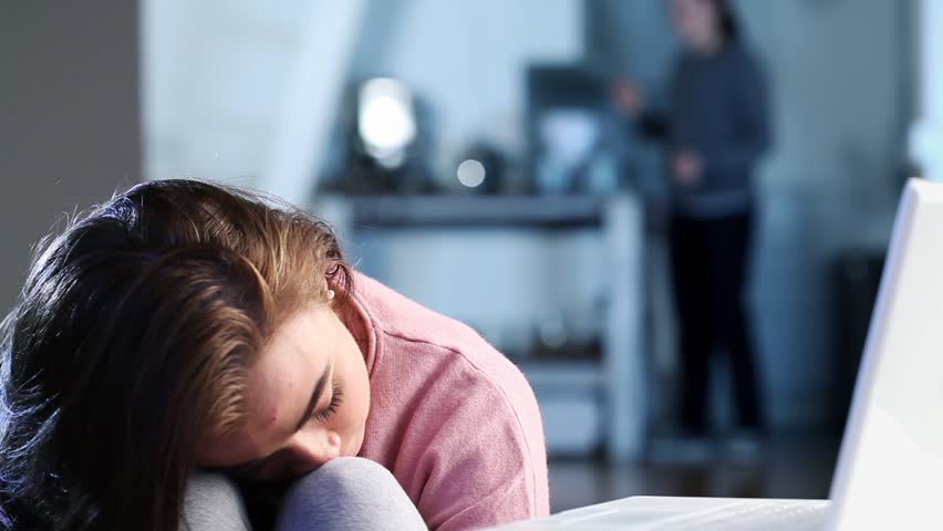 Close-up of depressed teenager looking sad and upset at home