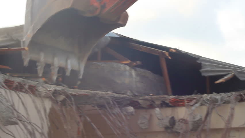 Building demolition, excavator and twisted rebars

