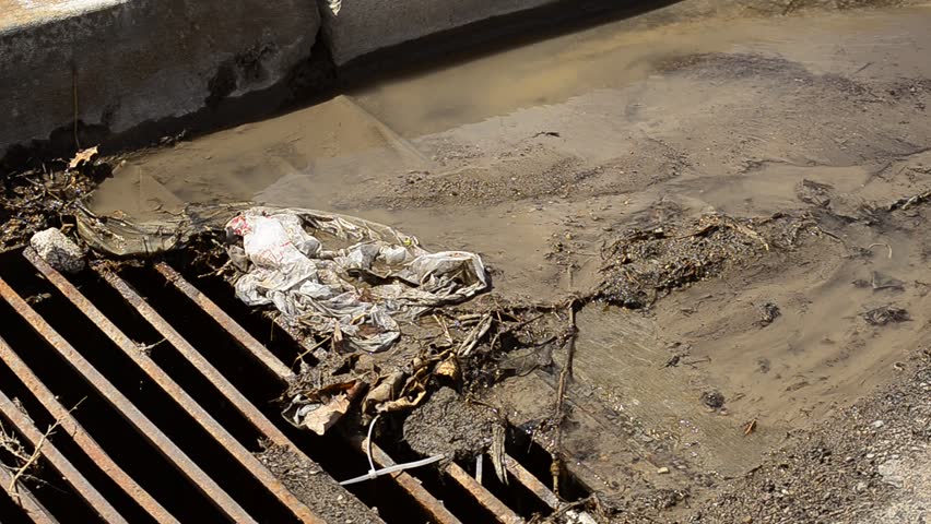 Gutter drain with trash and water flowing
