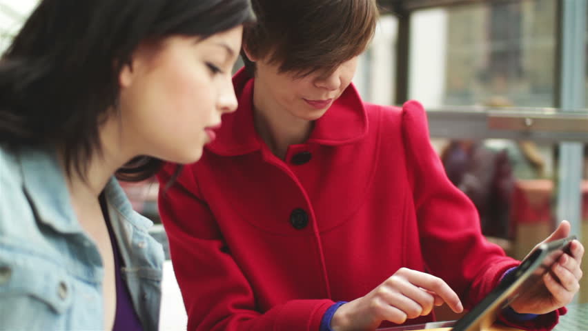 Female friends with tablet computer in restaurant
