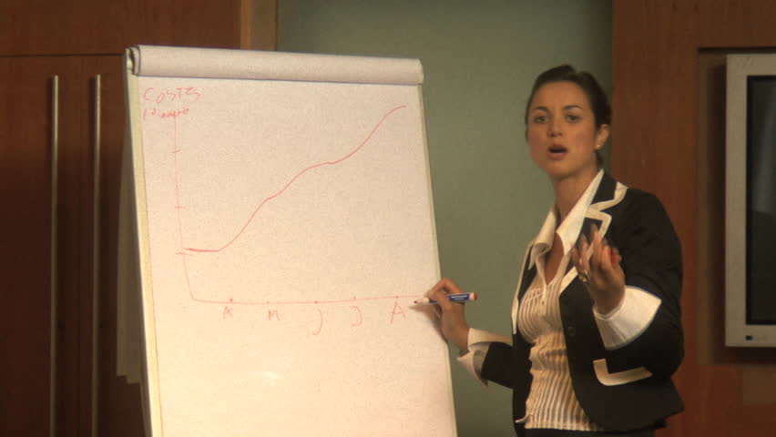 MEDIUM SHOT PAN OF A BUSINESSWOMAN GIVING A PRESENTATION
