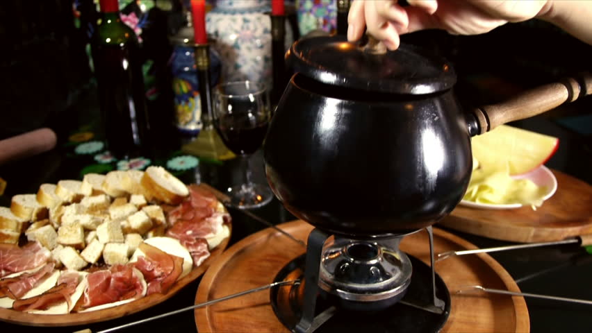 Swiss Fondue Sequence (HD). Fondue dinner table with bread, cheeses and ham with forks and candles shot on a sequence with different angles. 