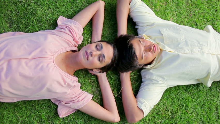 Peaceful couple napping together on the grass in a parkland