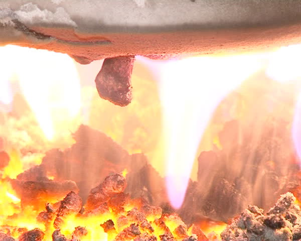 closeup of burning straw granules in boiler. flames and fire details. ecologic fuel use for home heating.