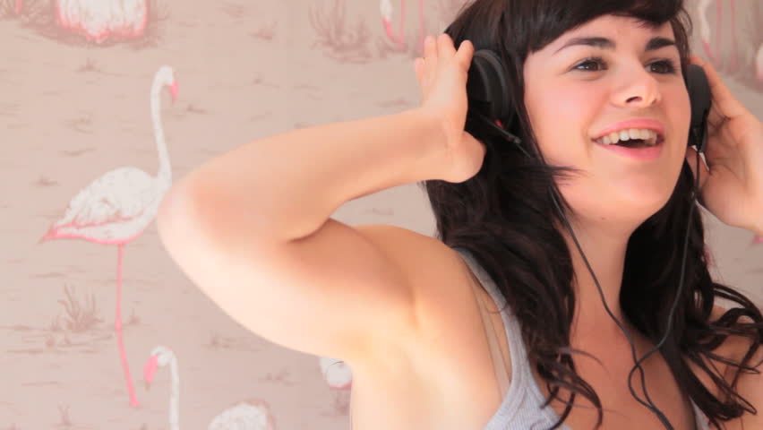 Female singing and listening to music on headphones