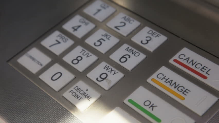 Man pressing keypad of an ATM machine
